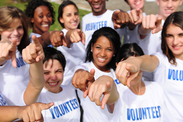 Happy volunteers pointing with index finger